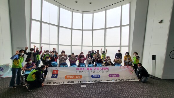 서울시립송파전문요양원 이용자와 가족들이 롯데타워 전망대에서 기념촬영을 하고 있다.사진제공 (사)나누며하나되기